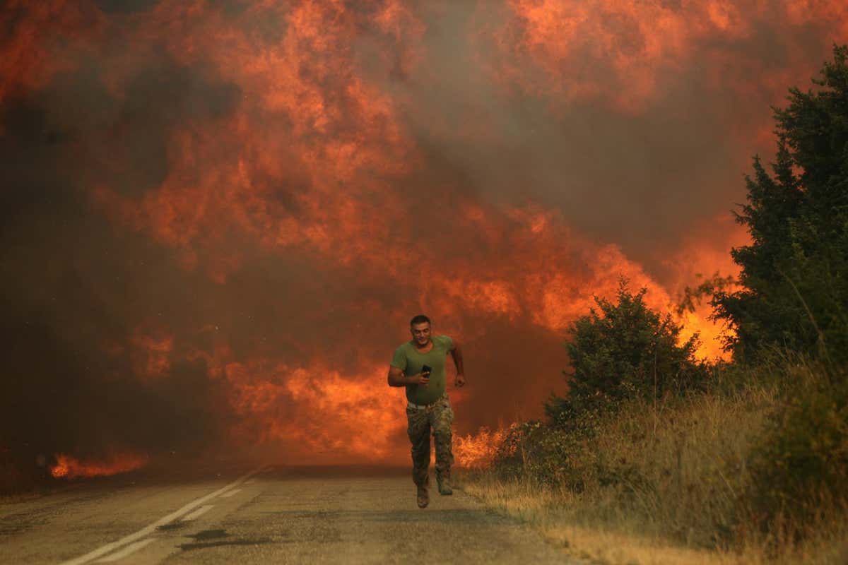 EVROS, GREECE - AUGUST 31: A firefighters runs as wildfire intensifies in the village of Sidiro and Yannuli in Evros, Greece on August 31, 2023. Efforts to extinguish wildfire continues. (Photo by Ayhan Mehmet/Anadolu Agency via Getty Images)