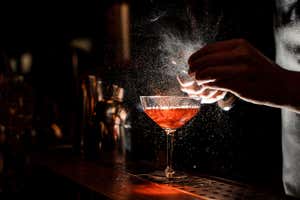 A bartender makes a cocktail in a bar